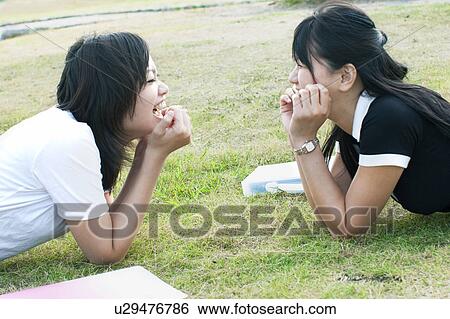 Young woman talking lying on grass View Large Photo Image Stock Photograph - Young woman talking lying on grass. Fotosearch