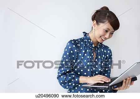Young woman using laptop, smiling, white background, copy space View Large Photo Image Stock Image - Young woman using laptop, smiling, white background, copy space. Fotosearch