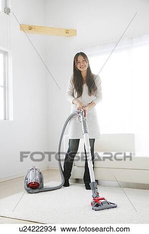 Picture - Young Woman Vacuuming the Floor. Fotosearch