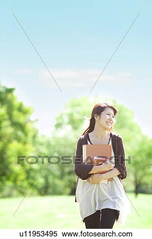 Stock Photography - Young woman walking at a park, Japan. Fotosearch