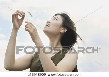 Young woman wearing a dress and looking up View Large Photo Image Stock Photo - Young woman wearing a dress and looking up. Fotosearch