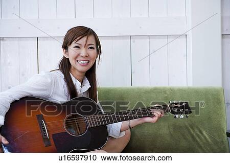 Stock Image - Young Woman With Acoustic Guitar. Fotosearch
