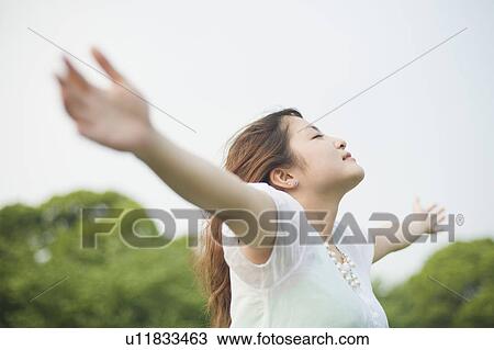 Stock Image - Young woman with arms out. Fotosearch