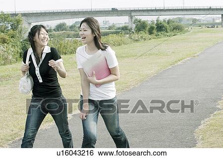 Young women holding a file and walking View Large Photo Image Stock Photograph - Young women holding a file and walking. Fotosearch