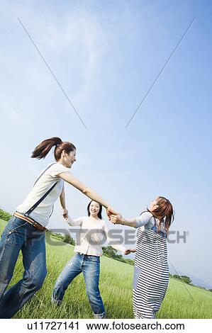 Young Women Holding Hands and Walking in a Circle View Large Photo Image Stock Image - Young Women Holding Hands and Walking in a Circle. Fotosearch