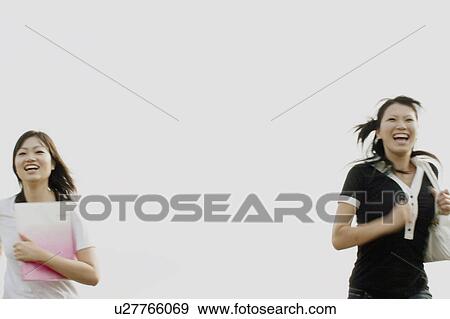 Stock Photo - Young women running and smiling. Fotosearch