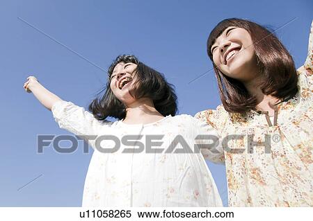 Young women standing side by side, Japan View Large Photo Image Stock Photography - Young women standing side by side, Japan. Fotosearch