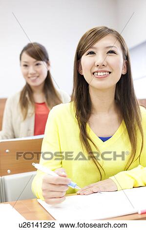 Stock Image - Young women studying in classroom, Japan. Fotosearch