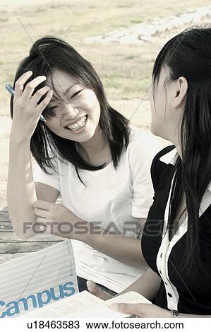 Stock Image - Young women studying outdoors. Fotosearch