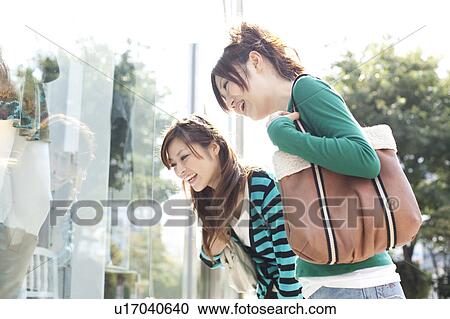 Stock Image - Young women window shopping, Japan. Fotosearch