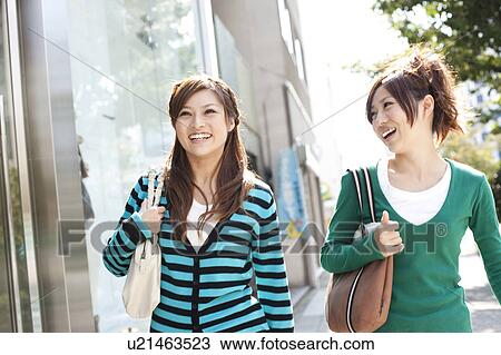Stock Image - Young women window shopping, Japan. Fotosearch
