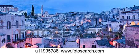 Aerial panorama of ancient town of Matera with tufa houses, Duomo and Campanile on hill beyond, at dusk with night illumination, Puglia, Southern Italy, View Large Photo Image Stock Photograph - Aerial panorama of ancient town of Matera with tufa houses, Duomo and Campanile on hill beyond, at dusk with night illumination, Puglia, Southern Italy,. Fotosearch