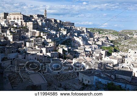 Aerial panorama of ancient town of Matera with tufa houses, Duomo Campanile on hill beyond, sunny spring afternoon with blue sky, Puglia, Southern Italy, View Large Photo Image Stock Photography - Aerial panorama of ancient town of Matera with tufa houses, Duomo Campanile on hill beyond, sunny spring afternoon with blue sky, Puglia, Southern Italy,. Fotosearch