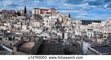 Stock Image - Aerial view of ancient town of Matera with tufa houses, sunny spring afternoon with blue sky, Puglia, Southern Italy,. Fotosearch
