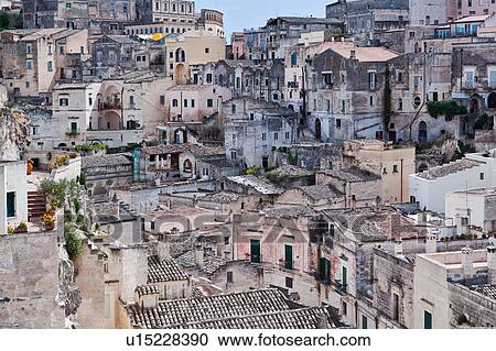 Stock Image - Aerial view of ancient town of Matera with tufa houses, sunny spring afternoon with blue sky, Puglia, Southern Italy. Fotosearch