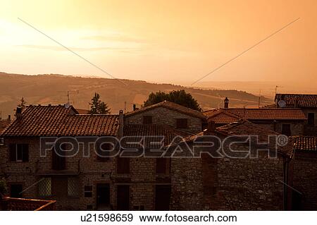 Stock Photo - Aerial view of Italian rooftops and piazza, during rainstorm with spectacular sunset sky, Umbria, Italy. Fotosearch
