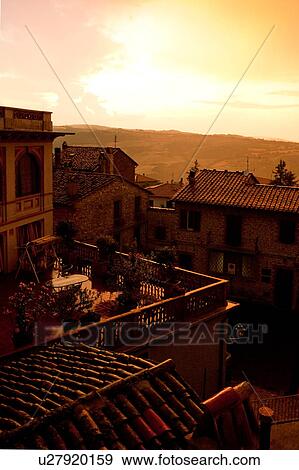 Stock Photo - Aerial view of Italian rooftops and piazza, during rainstorm with spectacular sunset sky, Umbria, Italy. Fotosearch