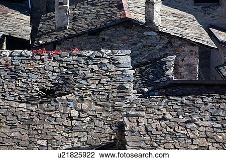 Stock Image - Aerial view of village slate roofs, in various states of disrepair, and autumn colours of red ivy vine, Lombardy, Italy. Fotosearch