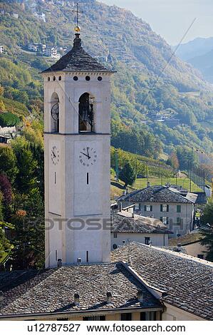 Aerial view of village stone church with bell tower, slate roofs, and autumn colours of trees, with background of mountain slopes beyond, Lombardy, Italy View Large Photo Image Stock Photo - Aerial view of village stone church with bell tower, slate roofs, and autumn colours of trees, with background of mountain slopes beyond, Lombardy, Italy. Fotosearch