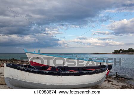 Beached wooden fishing boats on rocky shore, with skyscape at sunset, and headland across inlet in background, Puglia, Southern Italy View Large Photo Image Picture - Beached wooden fishing boats on rocky shore, with skyscape at sunset, and headland across inlet in background, Puglia, Southern Italy. Fotosearch
