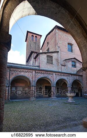 Stock Photography - Church of Santo Stefano, complex of seven churches, showing Cortile di Pilato (Pilate's courtyard) with highly decorated tiled porticos and ancient stone baptismal font, tower of Chiesa di Crocefisso (Church of the Crucifixion) beyond, Bologna, Italy. Fotosearch