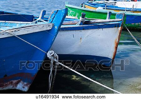 Picture - Close up view: prows of wooden painted blue and green fishing boats moored in Porto Cesareo harbour, sunny spring morning, Salento, Puglia, Southern Italy. Fotosearch