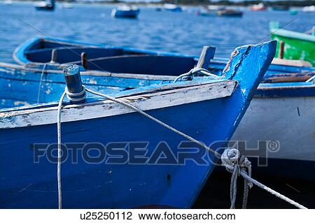 Close up view: prows of wooden painted blue and green fishing boats moored in Porto Cesareo harbour, sunny spring morning, Salento, Puglia, Southern Italy View Large Photo Image Stock Image - Close up view: prows of wooden painted blue and green fishing boats moored in Porto Cesareo harbour, sunny spring morning, Salento, Puglia, Southern Italy. Fotosearch
