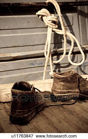 Stock Photo - Desaturated image of workboots and rope in back of truck, 'antique faded" closeup, Italy. Fotosearch