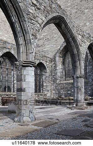 Stock Photo - Detail of cloister of St. Auden's church, monochrome, showing Romanesque columns and arches, with tombstones set into ground, Dublin, Southern Ireland. Fotosearch
