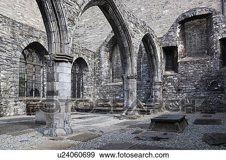 Stock Photo - Detail of cloister of St. Auden's church, monochrome, showing Romanesque columns and arches, with tombstones set into ground, Dublin, Southern Ireland. Fotosearch