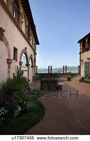 Stock Photo - Detail of courtyard of Italian Renaissance convent, with arched windows and balustrade, brick and stucco, landscape beyond, on sunny spring morning, Todi, Umbria. Fotosearch