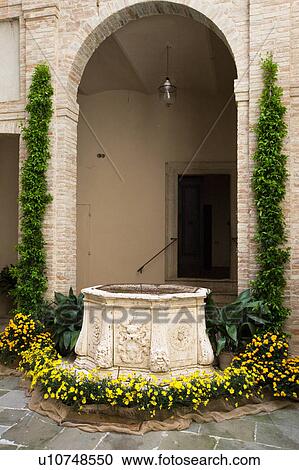 Detail of inner courtyard of Italian Renaissance palazzo, decorated with flowers, with arched entrance beyond stone well, brick and stucco, Todi, Umbria View Large Photo Image Stock Image - Detail of inner courtyard of Italian Renaissance palazzo, decorated with flowers, with arched entrance beyond stone well, brick and stucco, Todi, Umbria. Fotosearch