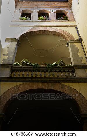 Stock Photo - Detail of inner courtyard of Italian Renaissance palazzo, with arched windows and balustrade, brick and stucco, Todi, Umbria. Fotosearch