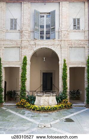Detail of inner courtyard of Italian Renaissance palazzo, decorated with flowers, with arched entrance beyond stone well, brick and stucco, Todi, Umbria View Large Photo Image Stock Photo - Detail of inner courtyard of Italian Renaissance palazzo, decorated with flowers, with arched entrance beyond stone well, brick and stucco, Todi, Umbria. Fotosearch