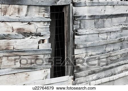 Stock Photo - Detail of original wooden housing, wooden plank walls, and wire-meshed window, desaturated image, Bodie pioneer village, California. Fotosearch