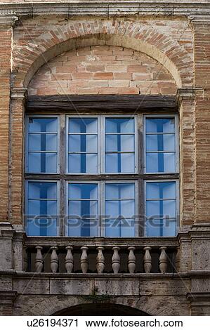 Stock Image - Detail of Renaissance palace window with decorative arch stonework surround, and carved stone balustrade, Todi, Umbria, Italy. Fotosearch