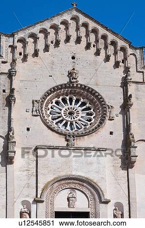 Detail of Romanesque facade of Duomo, with typical stone carved scroll work and statues around rose window, and arched decorated doorway, sunny spring afternoon, Matera, Puglia, Southern Italy View Large Photo Image Stock Image - Detail of Romanesque facade of Duomo, with typical stone carved scroll work and statues around rose window, and arched decorated doorway, sunny spring afternoon, Matera, Puglia, Southern Italy. Fotosearch