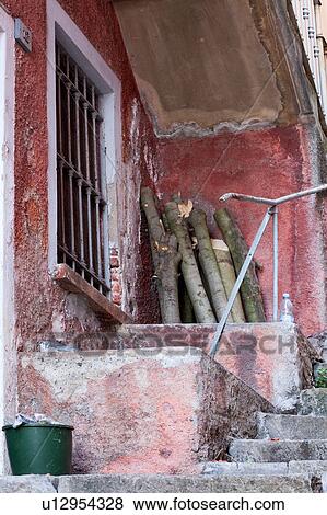Stock Photo - Detail of steep uneven stone stairway up narrow alley with walls of houses painted red/orange in typical evocative style of Northern Italy. Fotosearch