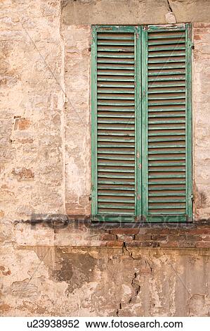 Stock Image - Detail of stone wall of medieval palace, with single green-shuttered window, Todi, Umbria, Italy. Fotosearch