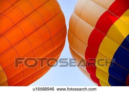 Detail of two brightly coloured hot air balloons "kissing", with blue sky beyond View Large Photo Image Stock Photograph - Detail of two brightly coloured hot air balloons "kissing", with blue sky beyond. Fotosearch