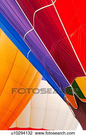 Detail of two hot air balloons overlapping: multicoloured red and purple balloon in front, orange balloon behind View Large Photo Image Stock Image - Detail of two hot air balloons overlapping: multicoloured red and purple balloon in front, orange balloon behind. Fotosearch