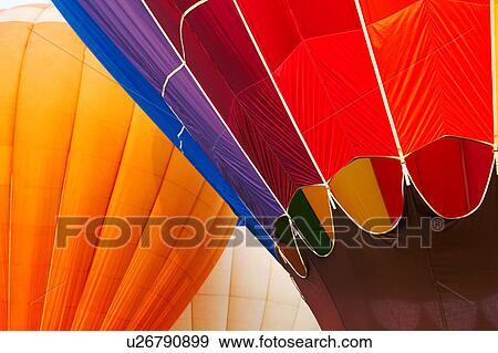 Detail of two hot air balloons overlapping: multicoloured red and purple balloon in front, orange balloon behind View Large Photo Image Stock Photo - Detail of two hot air balloons overlapping: multicoloured red and purple balloon in front, orange balloon behind. Fotosearch