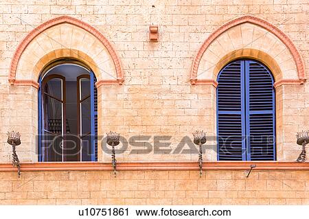 Detail of two medieval palace windows with decorative arch stonework surround, and wrought iron candle holders below, Todi, Umbria, Italy View Large Photo Image Stock Image - Detail of two medieval palace windows with decorative arch stonework surround, and wrought iron candle holders below, Todi, Umbria, Italy. Fotosearch