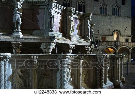 Detail, showing sculpted figures, of Fontana Maggiore (Great Fountain) in Piazza IV Novembre, Perugia with facade of Palazzo dei Priori (Town Hall) behind, at dusk, Umbria, Italy View Large Photo Image Stock Image - Detail, showing sculpted figures, of Fontana Maggiore (Great Fountain) in Piazza IV Novembre, Perugia with facade of Palazzo dei Priori (Town Hall) behind, at dusk, Umbria, Italy. Fotosearch