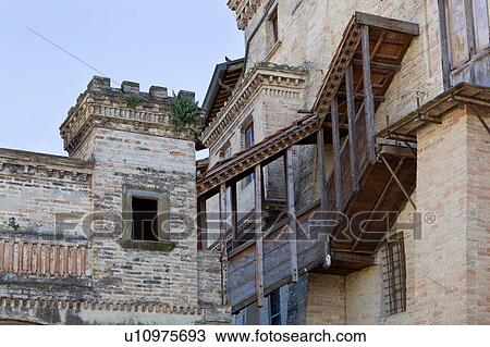 Stock Image - Detail view of back of medieval stone castle with merloned towers, and wooden balcony, Montefalco, Umbria, Italy. Fotosearch