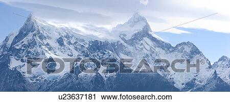 Early morning panorama view of snow covered Cerro Paine Grande mountain range, Torres del Paine, with dramatic clouds, Southern Chile, Patagonia View Large Photo Image Stock Image - Early morning panorama view of snow covered Cerro Paine Grande mountain range, Torres del Paine, with dramatic clouds, Southern Chile, Patagonia. Fotosearch
