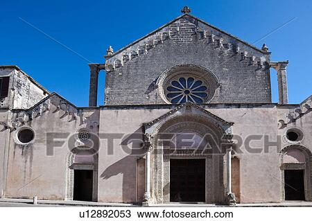 Stock Image - Exterior facade of Romanesque Basilica of Santa Caterina. with stylised carved stone decoration, columns with lions, and rose window, Galatina, Salento, Puglia, Southern Italy. Fotosearch