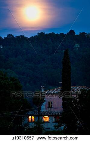 Farmhouse, lit interior, at dusk with moon rising behind wooded hillside, Umbria, Italy View Large Photo Image Stock Photo - Farmhouse, lit interior, at dusk with moon rising behind wooded hillside, Umbria, Italy. Fotosearch