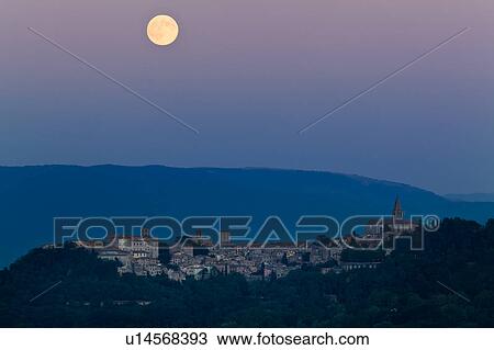 Full moon rising over medieval hilltop town of Todi, with spire of San Fortunato, and town lights illuminated at dusk, Umbria, Italy View Large Photo Image Stock Image - Full moon rising over medieval hilltop town of Todi, with spire of San Fortunato, and town lights illuminated at dusk, Umbria, Italy. Fotosearch