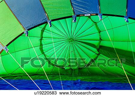 Stock Image - Interior of green and blue striped balloon, lying on ground, before take-off. Fotosearch